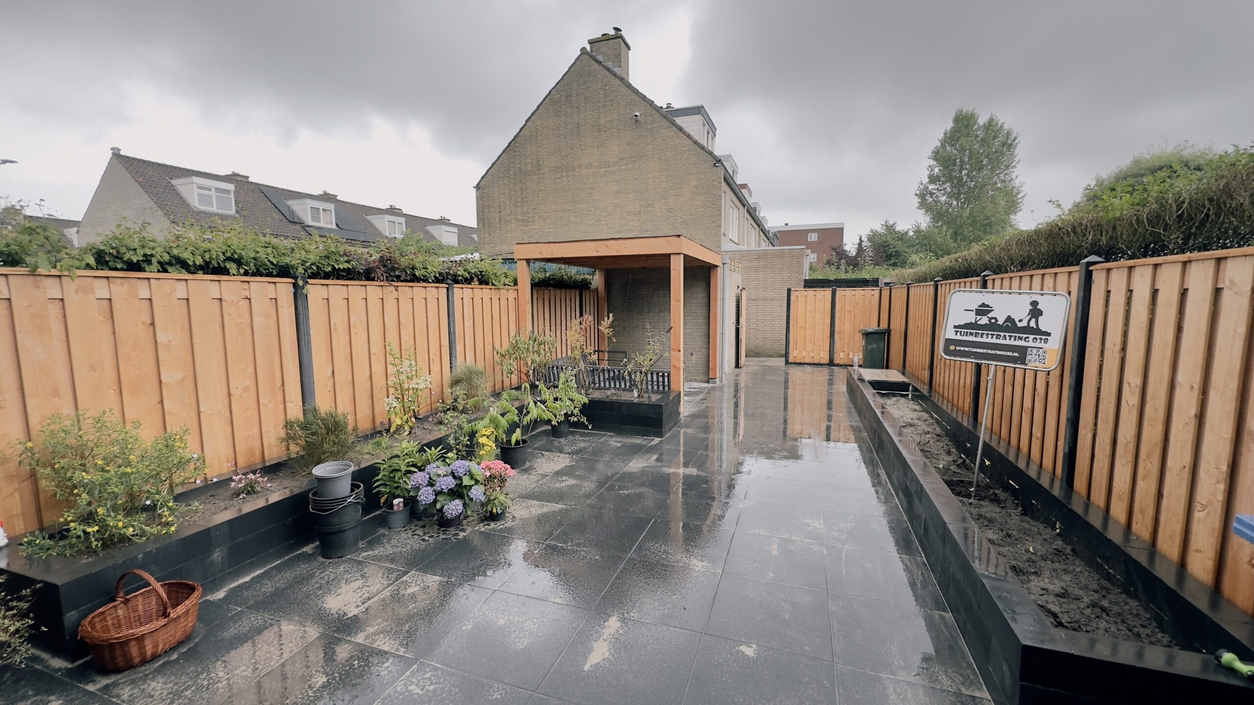 tuin met overkapping, bestrating en beplanting